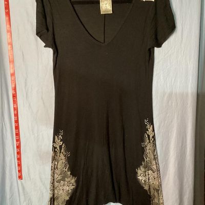 Sale Photo Thumbnail #27: Vocal brand black short sleeve V-neck tunic top or mini dress featuring an asymmetrical handkerchief hemline. Elaborately embellished with lace print, scrollwork, and rhinestone-encrusted cross designs on the lower sides. Made in the USA. Measures approxi