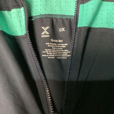 Sale Photo Thumbnail #35: Xersion brand Quick-Dri full-zip athletic jacket in black with teal/mint green perforated accent panels. Features front zip pockets and high collar. Made of 87% polyester and 13% spandex. Appears lightly used with no major flaws noted. Tag size 0X.