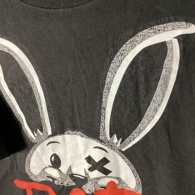 Sale Photo Thumbnail #39: Black Brooklyn Vertical short sleeve t-shirt featuring a graphic print of a bunny with an 'X' eye and red 'BAD' lettering. Made of 100% cotton in Mexico. Size XL. Length measures approximately 28.5 inches from top shoulder to bottom hem. Shows light wear 
