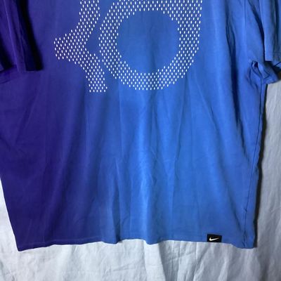 Sale Photo Thumbnail #51: Men's Nike short sleeve t-shirt featuring the Kevin Durant KD logo printed on the front. Features a two-tone blue and purple color block style design. Marked size XL (Athletic Cut). Gently used condition with light wear and minor wrinkling.