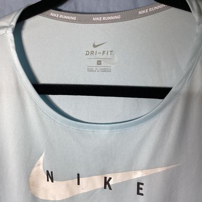 Sale Photo Thumbnail #55: Women's Nike Running Dri-Fit short sleeve t-shirt in light blue with front Nike graphic. Size 1X. Made in Cambodia. Pre-owned condition with minor wear to the graphic transfer.