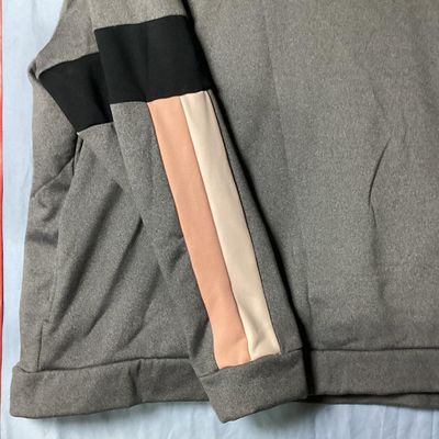 Sale Photo Thumbnail #82: Nike women's crewneck pullover sweatshirt in heather grey featuring embroidered swoosh logo on chest, fleece-lined interior, and black, peach, and cream colorblock stripes on the sleeves. Size XL Made in Vietnam. Approx. length 28-29 inches. Good pre-owne