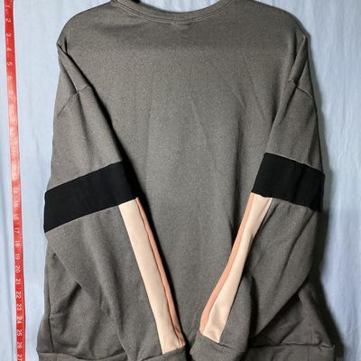 Sale Photo Thumbnail #83: Nike women's crewneck pullover sweatshirt in heather grey featuring embroidered swoosh logo on chest, fleece-lined interior, and black, peach, and cream colorblock stripes on the sleeves. Size XL Made in Vietnam. Approx. length 28-29 inches. Good pre-owne