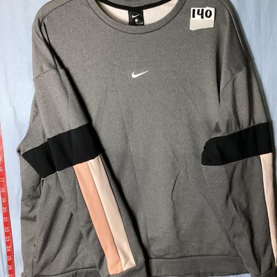 Sale Photo Thumbnail #78: Nike women's crewneck pullover sweatshirt in heather grey featuring embroidered swoosh logo on chest, fleece-lined interior, and black, peach, and cream colorblock stripes on the sleeves. Size XL Made in Vietnam. Approx. length 28-29 inches. Good pre-owne