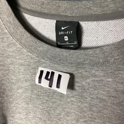 Sale Photo Thumbnail #85: Grey Nike Dri-FIT crewneck sweatshirt featuring 'JUST DO IT.' printed along the left sleeve and a small black Nike swoosh on the upper back. Tagged size XL (Extra Large). Shows light overall wear consistent with normal use, with no major stains or holes v