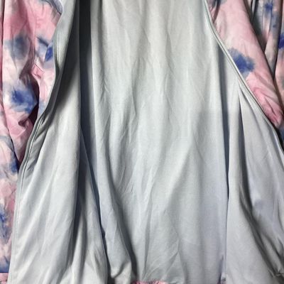 Sale Photo Thumbnail #94: New Balance hooded windbreaker/lightweight jacket featuring a pink, blue, and white tie-dye watercolor pattern. Includes full front zipper, zippered side pockets, mesh lining, hooded drawstrings, and an adjustable cinch hemline. Size XL. Made in Vietnam. 