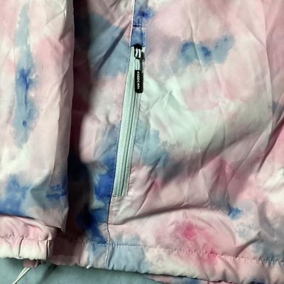 Sale Photo Thumbnail #93: New Balance hooded windbreaker/lightweight jacket featuring a pink, blue, and white tie-dye watercolor pattern. Includes full front zipper, zippered side pockets, mesh lining, hooded drawstrings, and an adjustable cinch hemline. Size XL. Made in Vietnam. 