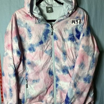 Sale Photo Thumbnail #91: New Balance hooded windbreaker/lightweight jacket featuring a pink, blue, and white tie-dye watercolor pattern. Includes full front zipper, zippered side pockets, mesh lining, hooded drawstrings, and an adjustable cinch hemline. Size XL. Made in Vietnam. 