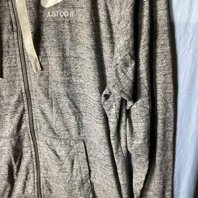 Sale Photo Thumbnail #114: Nike heather gray full-zip hooded sweatshirt featuring white 'Nike Just Do It' logo on the chest. Has front hand pockets, drawstring hood, and raglan sleeves. Tag size XXL (1XG/2EG). Lightly worn in good pre-owned condition with no major stains, rips, or 
