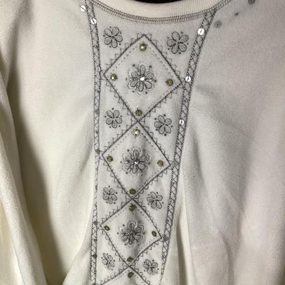 Sale Photo Thumbnail #149: An Alfred Dunner long-sleeve fleece sweatshirt in cream/white, featuring intricate floral embroidery, sequins, and bead accents along the front panel. Made from 100% polyester. Size XL. Appears to be in good pre-owned condition with minor signs of wear.