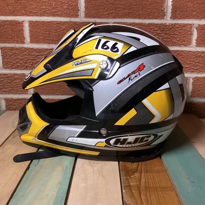 Sale Photo Thumbnail #235: HJC CL-X4 Fuel off-road/motocross motorcycle helmet in yellow, silver, black, and white graphics. Marked as Adult Large size with Advanced Ventilation System (AVS). Inner label indicates manufacturing date of September 2001. Features visor, chin guard ven
