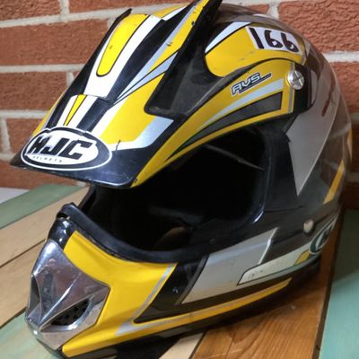 Sale Photo Thumbnail #232: HJC CL-X4 Fuel off-road/motocross motorcycle helmet in yellow, silver, black, and white graphics. Marked as Adult Large size with Advanced Ventilation System (AVS). Inner label indicates manufacturing date of September 2001. Features visor, chin guard ven
