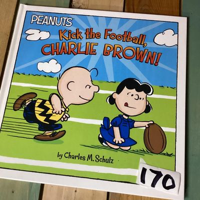 Sale Photo Thumbnail #258: Hardcover Peanuts picture book titled 'Kick the Football, Charlie Brown!' by Charles M. Schulz. Features full-color illustrations featuring Charlie Brown and Lucy. Clean interior pages with bright orange endpapers. Overall in good condition with minimal w