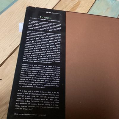 Sale Photo Thumbnail #304: Hardcover photography book titled 'In Focus: National Geographic Greatest Portraits'. Features 280 portrait photographs spanning over a century. Includes original dust jacket. Dust jacket shows some wear and a tear on the back corner, but internal pages r