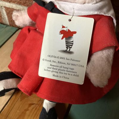 Sale Photo Thumbnail #315: Pairing of an 'Olivia' hardcover children's book by Ian Falconer alongside a matching 2001 Gund plush doll made exclusively for FAO Schwarz. Plush includes original hangtags and sewn-in tags. Both items are in good pre-owned condition with light wear.