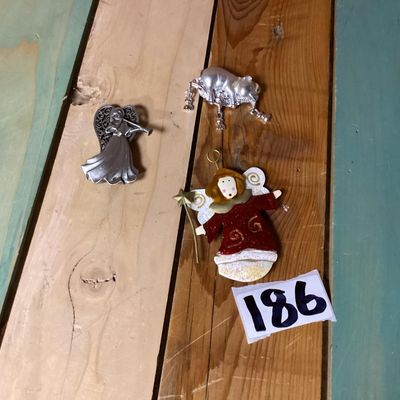 Sale Photo Thumbnail #352: Lot of 3 decorative brooches featuring an angel with a trumpet, a painted angel holding a wand/star, and a silver-tone pig figure. Each piece measures approximately 2 to 4 inches long. Pre-owned condition with light surface wear visible.