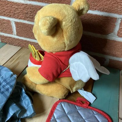 Sale Photo Thumbnail #360: Lot of Disney Winnie the Pooh collectibles including a Cupid Valentine plush with wings, a honey pot, bow and arrow; a blue plaid umbrella with Pooh graphic and honey pot handle; and a quilted Christmas themed pot holder. Items show light wear consistent 