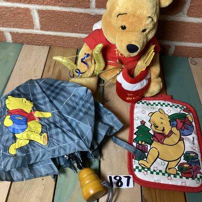 Sale Photo Thumbnail #356: Lot of Disney Winnie the Pooh collectibles including a Cupid Valentine plush with wings, a honey pot, bow and arrow; a blue plaid umbrella with Pooh graphic and honey pot handle; and a quilted Christmas themed pot holder. Items show light wear consistent 