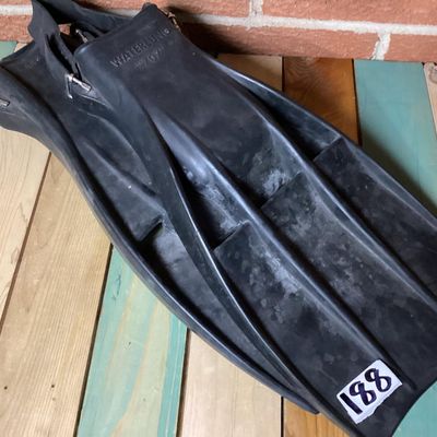 Sale Photo Thumbnail #364: Pair of vintage black rubber swim/scuba fins marked 'WATERLUNG 707' and size 'LARGE'. Features open heel with adjustable heel straps and metal buckles. Fins show signs of age and wear including surface marks and scuffs consistent with light use. Rubber re