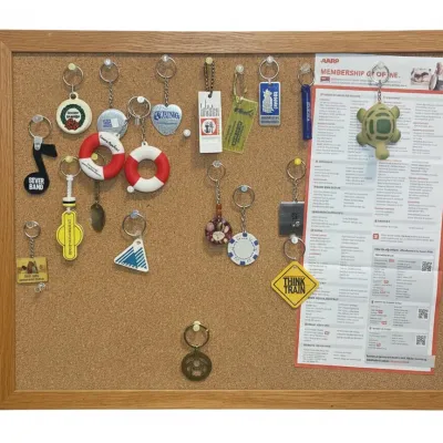 Sale Photo Thumbnail #454: Collection of assorted keychains on framed cork display board