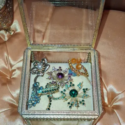 Sale Photo Thumbnail #714: Vintage rhinestone brooch collection in glass casket box