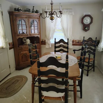 Vintage dining table set with four black ladder-back chairs 
