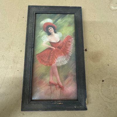 Sale Photo Thumbnail #157: Antique color print of a dancing girl in a red ruffled dress and plumed red hat, signed in the plate (lower right), in its original dark wood frame. Charming Edwardian-era décor.
Condition: Dust under glass, toning; frame shows wear and a chipped corner.