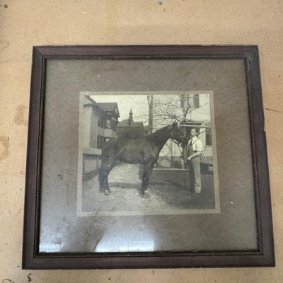 Sale Photo Thumbnail #158: Antique black and white photograph of a young man in overalls holding a horse, with Victorian houses and church steeple in the background. Original mat and wood frame. Toning and dust under glass.

Sold as-is, where-is. Local pickup or buyer-arranged 3rd-
