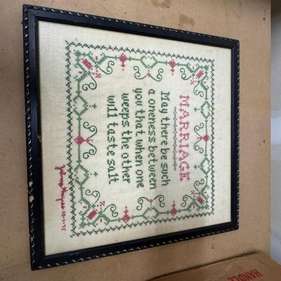 Sale Photo Thumbnail #159: Hand-stitched cross-stitch sampler in green and pink with decorative scroll border: "MARRIAGE – May there be such a oneness between you that when one weeps the other will taste salt." Signed and dated 10-1-75 by the maker. Black wood frame with decorati