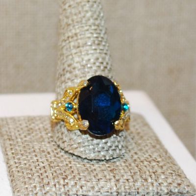 Size 11½ Large Blue Oval 4 Prong Stone Party Style Ring with Side Accents on a Gold Tone Band (8.2g)