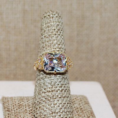 Size 7 Large Beveled Clear Glass Style Stone Ring with Triple Stone Side Accents on a Gold Tone Band (5.3g)