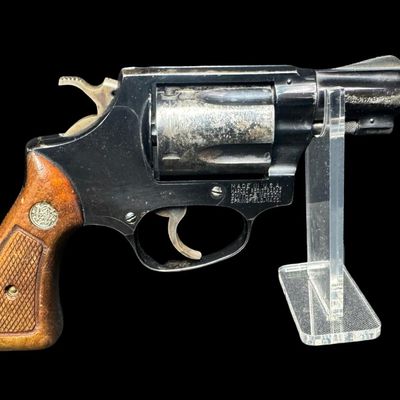 Sale Photo Thumbnail #13: This revolver has the no-dash serial number, meaning that it was issued prior to any significant mechanical changes made later by Smith & Wesson. It has the original diamond checkered wood grips. The barrel measures two inches long. This revolver shows so