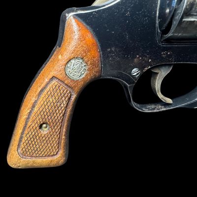 Sale Photo Thumbnail #15: This revolver has the no-dash serial number, meaning that it was issued prior to any significant mechanical changes made later by Smith & Wesson. It has the original diamond checkered wood grips. The barrel measures two inches long. This revolver shows so