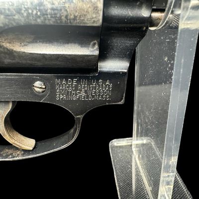 Sale Photo Thumbnail #14: This revolver has the no-dash serial number, meaning that it was issued prior to any significant mechanical changes made later by Smith & Wesson. It has the original diamond checkered wood grips. The barrel measures two inches long. This revolver shows so