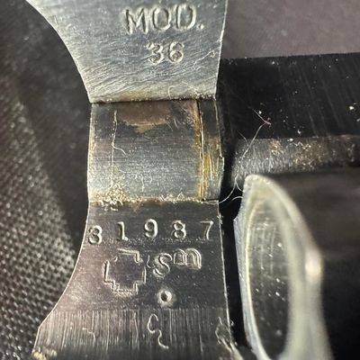 Sale Photo Thumbnail #18: This revolver has the no-dash serial number, meaning that it was issued prior to any significant mechanical changes made later by Smith & Wesson. It has the original diamond checkered wood grips. The barrel measures two inches long. This revolver shows so