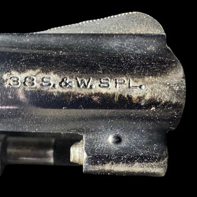 Sale Photo Thumbnail #16: This revolver has the no-dash serial number, meaning that it was issued prior to any significant mechanical changes made later by Smith & Wesson. It has the original diamond checkered wood grips. The barrel measures two inches long. This revolver shows so
