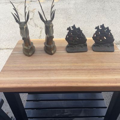 Sale Photo Thumbnail #42: Collection of four vintage bookends including a pair of brass deer/stag head figures and a pair of dark cast iron sailing ship motif bookends. Features detailed craftsmanship and natural age patina throughout. Good vintage condition with light wear consis