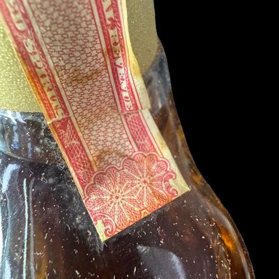 Sale Photo Thumbnail #30: This is believed to be from the 1970s. The bottle is in the shape of a pair of binoculars, and comes in a leather case. The tax stamp and label are intact. Both the bottle and case have age related wear. Measurement of case: 9.5”H x 6.25”W. Pre-auctio