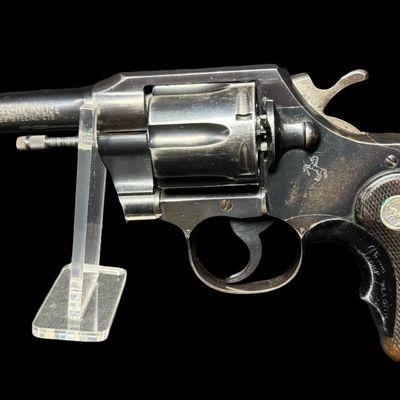 Sale Photo Thumbnail #49: This gun has the Rampant Colt logo stamped on the left side, which is crisp with no wear or re-bluing. It also has the original checkered walnut grips, which have minor wear. There are no major patches of wear to the bluing in general. There is holster we