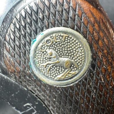 Sale Photo Thumbnail #50: This gun has the Rampant Colt logo stamped on the left side, which is crisp with no wear or re-bluing. It also has the original checkered walnut grips, which have minor wear. There are no major patches of wear to the bluing in general. There is holster we