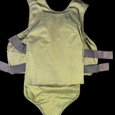 Sale Photo Thumbnail #69: This is olive drab in color, has a heavy-duty canvas/nylon blend body, and has distinctive dual brown suede/leather shooting pads on both shoulders to cushion a rifle or shotgun stock during recoil. The size is large. Pre-auction estimate: $100-$200. [RS]
