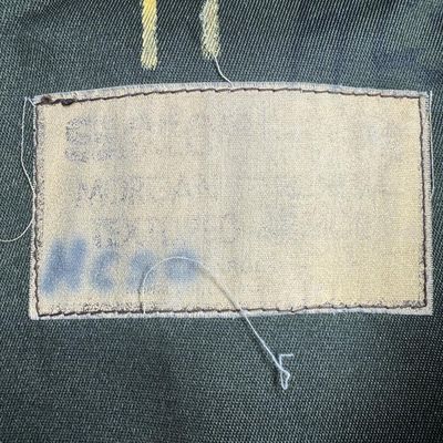 Sale Photo Thumbnail #70: This is olive drab in color, has a heavy-duty canvas/nylon blend body, and has distinctive dual brown suede/leather shooting pads on both shoulders to cushion a rifle or shotgun stock during recoil. The size is large. Pre-auction estimate: $100-$200. [RS]