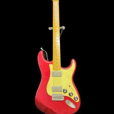 Sale Photo Thumbnail #148: This piece is believed to be completely original. It features a maple neck and fingerboard with 22 frets. It has Dual Hot vintage Alnico humbucking pickups with metal covers. The body is made of alder wood. This guitar was made in Mexico. The stand is inc