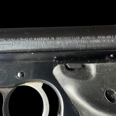 Sale Photo Thumbnail #190: The Ruger Mark 2 is a semi-automatic .22 long rifle rimfire pistol introduced in 1982 as an upgrade to the original Ruger Standard. It has a 10+1 capacity. It has a 4.75” barrel with fixed sights, and rubber ergonomic grips. The overall length is 9.5 in