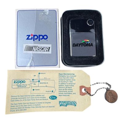 Sale Photo Thumbnail #203: Includes an NOS Daytona 500 Zippo lighter in the original packaging, and a vintage Zippo guarantee card. The lighter is from the 1998 Daytona 500. Pre-auction estimate: $75-$100. [RS]