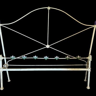 Sale Photo Thumbnail #93: Vintage full sized painted wrought iron full size headboard featuring an arched crest frame  cross-brace geometric support  purple finial accents  and colorful painted floral tile emblems across lower crossbar.  