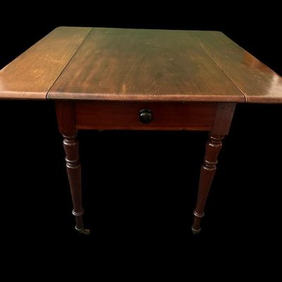 Sale Photo Thumbnail #126: 42"W (leaves) / 24"W (no leaves) × 45"L × 29"T Vintage Solid Wood Drop-Leaf Dining Table  features two fold-down end leaves and tapered legs and silverware drawer. Measurements: 42" wide w/leaves  24" w/o leaves  45" length  29" tall. Local  .  