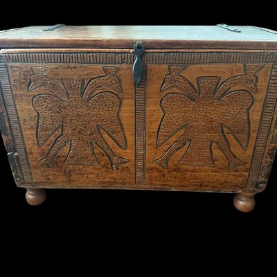 Sale Photo Thumbnail #141: 24"W × 11"D × 16"H Antique-style solid wood chest featuring deep relief-carved front panels with double-headed peacock motifs  stippled background  carved border trim  dark iron latch hardware  hinged top lid  and turned ball feet. Dimensions: 24" Wide 