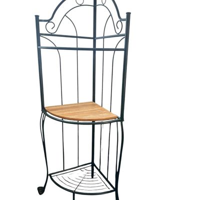 Sale Photo Thumbnail #152: 65"T × 25"W × 18"D Dark green metal scrollwork corner plant stand/shelf featuring arched crest wirework  top and bottom metal grid shelves  a center solid wood shelf insert  and scroll feet. Dimensions: 64" Tall x 25" Wide x 18" Deep.  