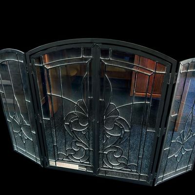 Sale Photo Thumbnail #158: Center 28.50 Sides 13.00 Total 42.00 Ornate 4-panel folding fireplace screen featuring heavy black metal frame  clear leaded glass panes with beveled edges  and Fleur-de-Lis stylized center motif. Center 28.50 Sides 13.00 Total 42.00  